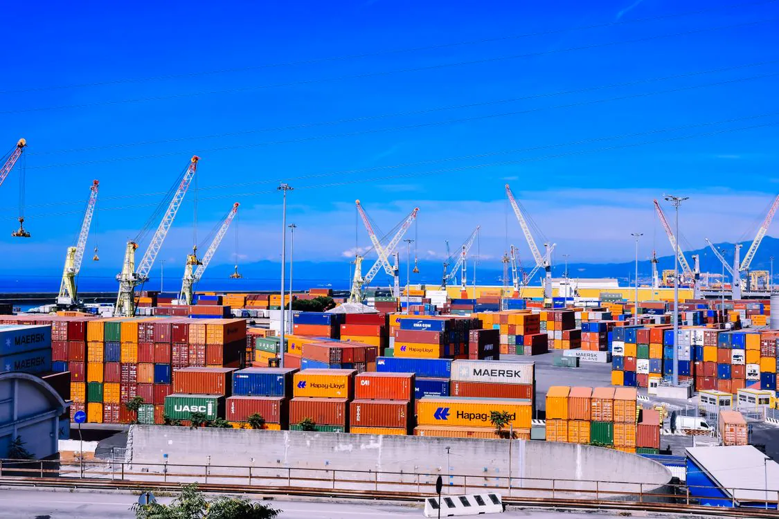 Terminal portuaire avec des conteneurs et des grues de manutention.