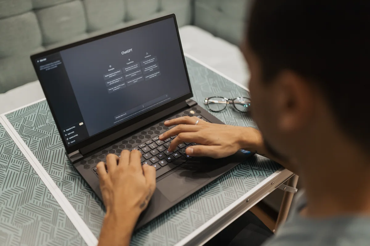 Personne utilisant une interface d’intelligence artificielle générative sur un ordinateur portable.
